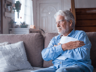 Older man alone in living room staring into the distance